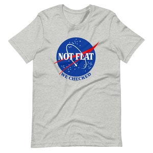 May include: A gray t-shirt with a blue and red graphic of the NASA logo. The text on the graphic says "NOT FLAT WE CHECKED".