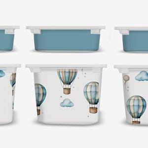 May include: Six white plastic storage bins with blue lids. The bins have a white background with a pattern of blue and brown hot air balloons and white clouds.