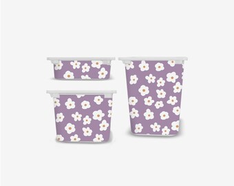 May include: Three storage containers with white lids. The containers are decorated with a repeating pattern of white flowers with yellow centers on a purple background. The containers are different sizes and shapes.