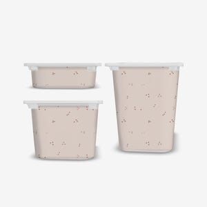 May include: Three plastic storage bins with a light pink background and a scattered pattern of small red dots. The bins are different sizes and have white lids.