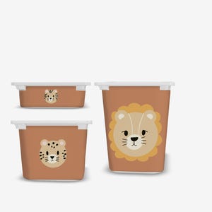 Op de afbeelding: Drie plastic opbergbakken met witte deksels en bruine zijden. De bakken hebben dierengezichten: een leeuw, een tijger en een luipaard.