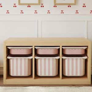 Könnte beinhalten: Ein helles Holzregal mit drei Fächern, in denen sich jeweils eine rosa-weiß gestreifte Box befindet. Die Boxen haben rosa Deckel. Im Hintergrund eine weiße Wand mit Kirschblüten-Aufklebern und ein Bett mit rosa gestreifter Bettwäsche.