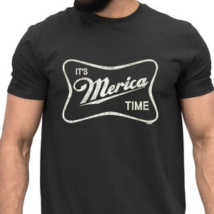 Könnte beinhalten: Schwarzes T-Shirt mit einem weißen Vintage-Grafikdruck, auf dem "It's Merica Time" steht.