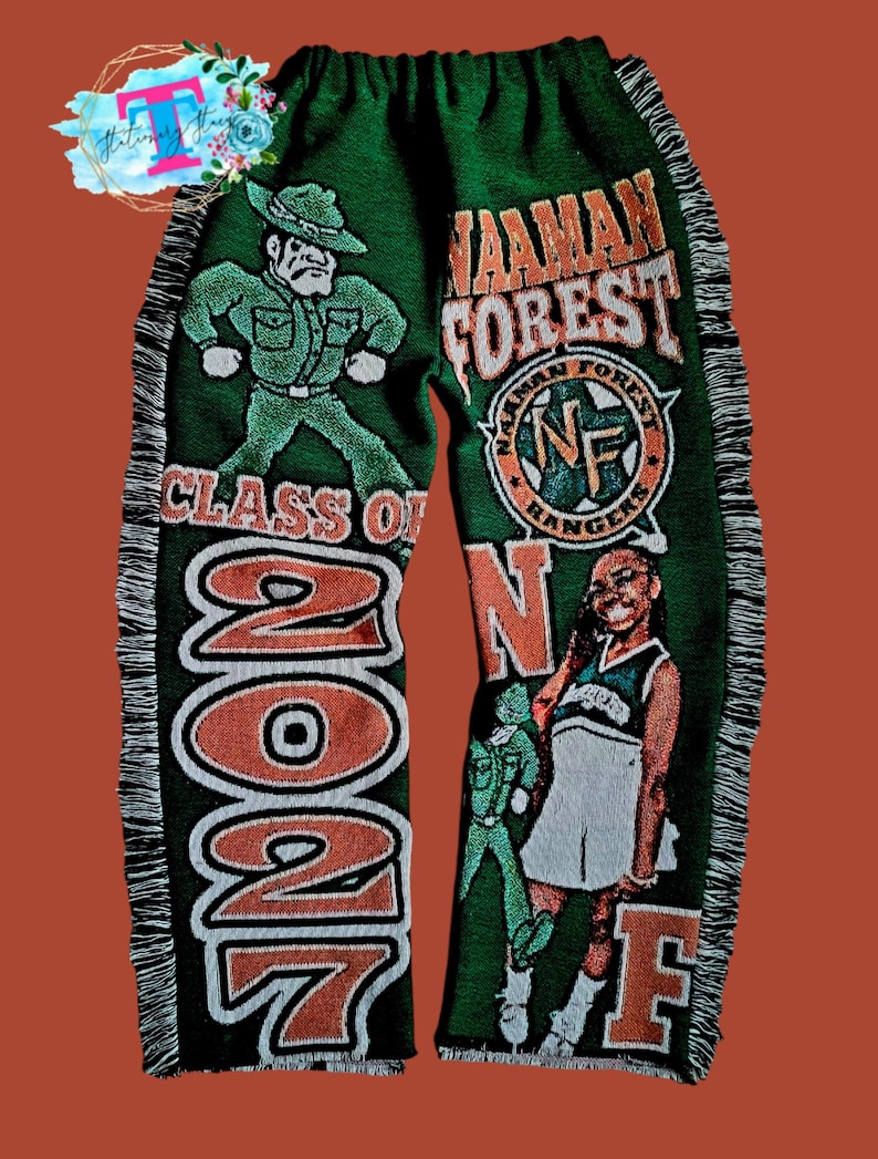 Puede incluir: Manta tejida verde y naranja con las palabras "Wauman Forest" y "Class of 2027". La manta presenta un guardabosques de dibujos animados y una animadora.