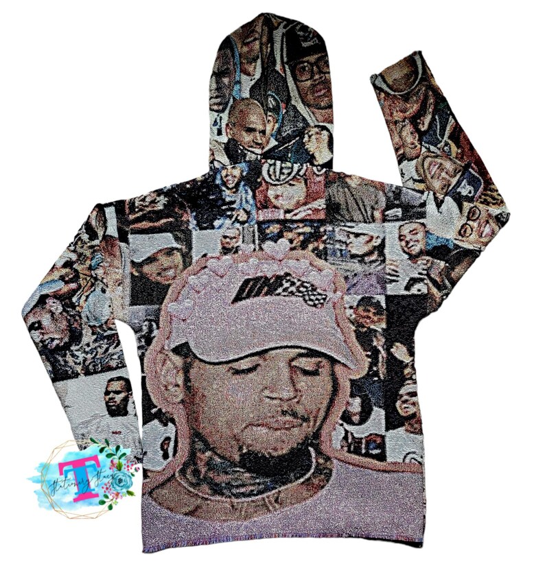 May include: A gray hooded sweatshirt with a collage of images of people, including a large image of a person wearing a pink hat with a racing stripe. The sweatshirt has a drawstring hood and long sleeves.