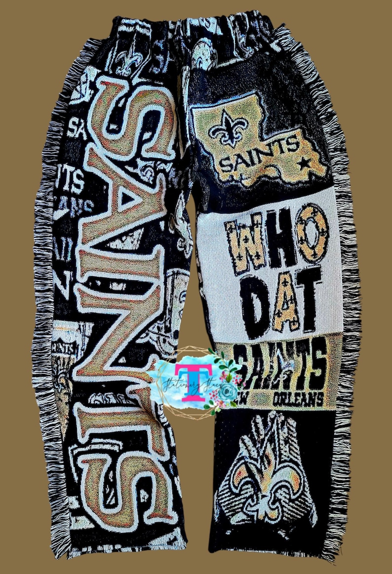 Puede incluir: Manta tejida negra y dorada con el logotipo de los New Orleans Saints y las palabras "Who Dat" y "Saints".