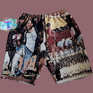 Puede incluir: Un par de pantalones cortos de tapicer&iacute;a marr&oacute;n y negro con una imagen colorida de personas en la parte delantera. La imagen incluye una persona con jeans azules y una camisa blanca, un grupo de personas con rojo y blanco, y un grupo de personas con blanco.