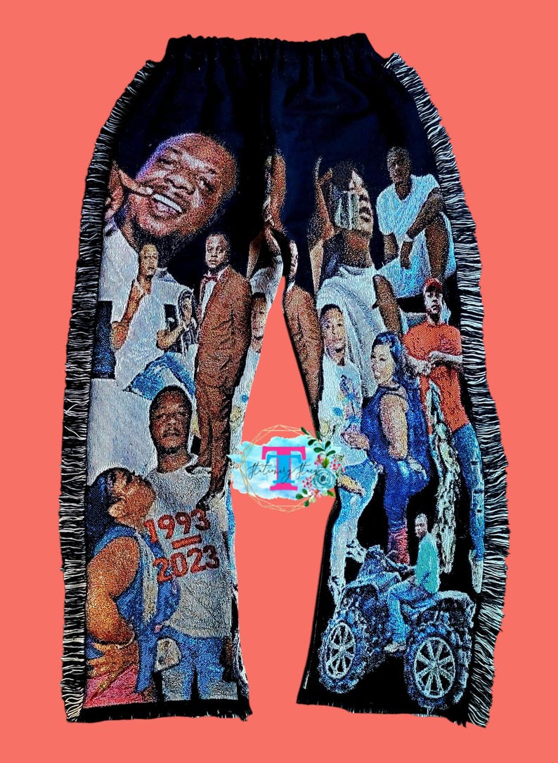 Puede incluir: Pantal&oacute;n negro con un collage de fotos impresas. Las fotos incluyen personas de diferentes edades y razas. El pantal&oacute;n tiene un ribete con flecos en los lados. El texto "1993-2023" es visible en la pierna izquierda.