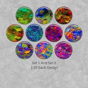 May include: A collection of ten circular cabochons featuring vibrant, abstract, multi-colored patterns including shades of green, blue, red, yellow, and purple. The text below reads Set 1 And Set 2 1 Of Each Design. Each piece has a unique texture.