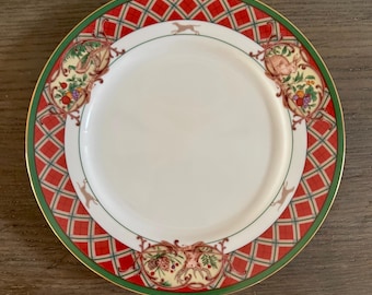 Peut inclure: Une assiette ronde en porcelaine avec un centre blanc et une large bordure à motif écossais rouge et vert. La bordure est ornée d'illustrations d'un lapin, d'un cerf et de grappes de fruits, rehaussée par un fin liseré doré.