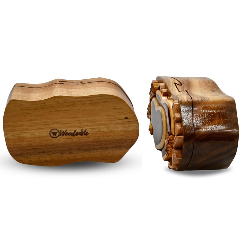 May include: A wooden puzzle box with a heart-shaped design and intricate carvings. The box is made of dark wood and has a natural finish. The box is closed and the lid is slightly ajar. The box is labeled "Woodenville" on the bottom.
