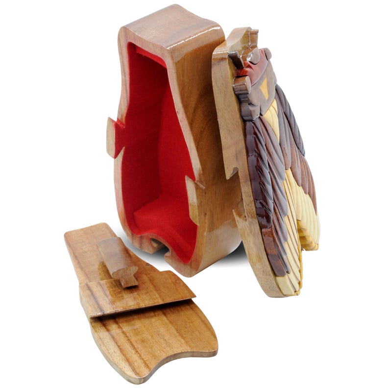 May include: A wooden puzzle box shaped like a penguin with a red felt interior. The box is open and the lid is off, revealing the intricate wooden puzzle pieces that make up the penguin's body.