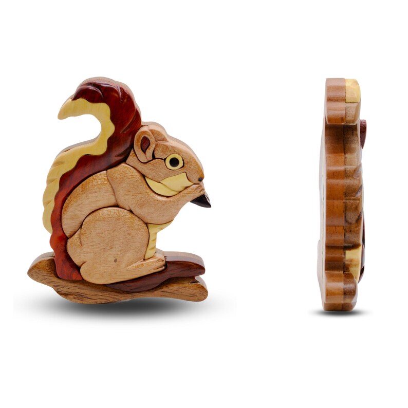 May include: A wooden squirrel puzzle, featuring a detailed design with various wood tones. The squirrel is posed on a branch, with a side view of the puzzle also shown. The puzzle is approximately 5 inches long.