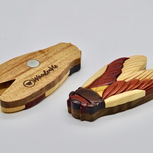 Puede incluir: Un im&aacute;n de madera con forma de cigarra con detalles intrincados y una variedad de tonos de madera. La parte posterior del im&aacute;n presenta el logotipo "Woodenvue" y un im&aacute;n plateado.