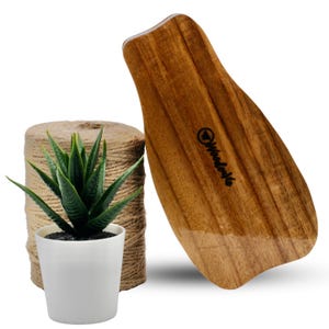 May include: A wooden paddle with a rounded shape and a smooth, polished surface. The paddle is made of light brown wood with darker brown streaks. The word "Woodcraft" is printed on the paddle in black lettering.