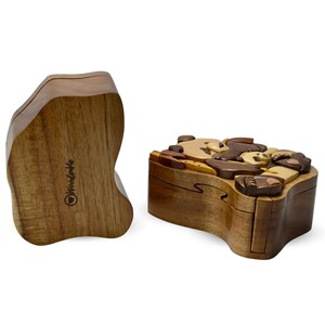 Puede incluir: Una caja de rompecabezas de madera con un dise&ntilde;o de oso. La caja est&aacute; hecha de m&uacute;ltiples piezas de madera que encajan para crear la forma del oso. La caja est&aacute; cerrada y la tapa es visible. La caja est&aacute; hecha por Woodenware.