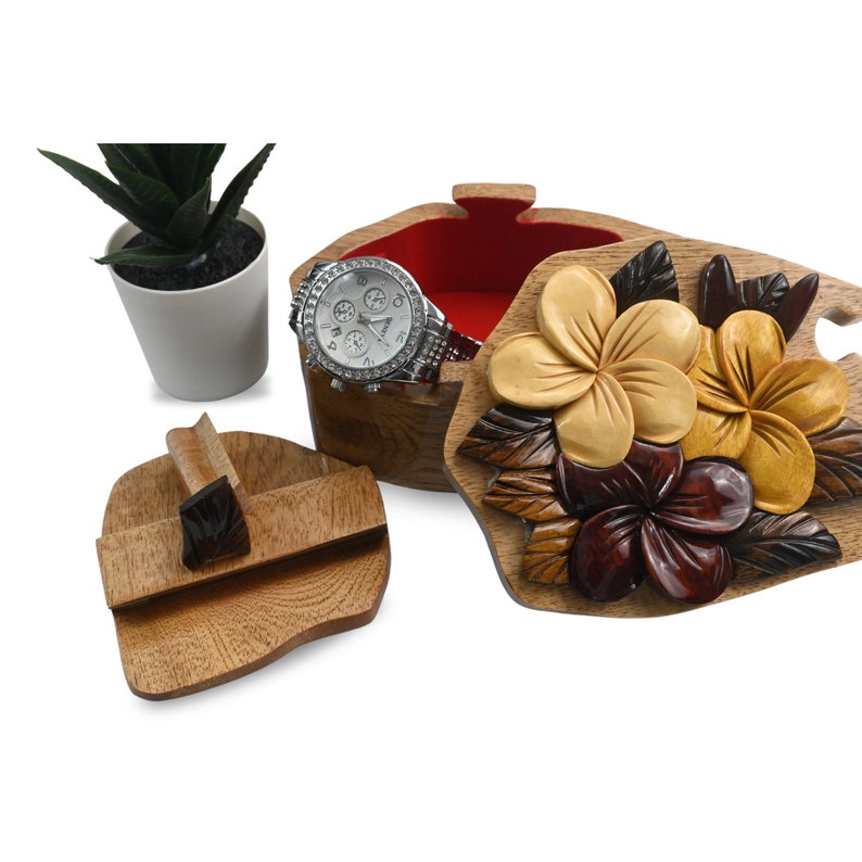 May include: A wooden puzzle box with a carved floral design. The box is open and a watch is inside. The box is made of light brown wood and the flowers are carved in shades of brown, yellow, and red.