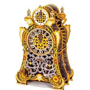 May include: A detailed wooden clock with intricate carvings and a gold finish. The clock face features Roman numerals and a delicate floral design.