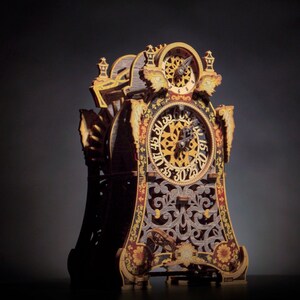 May include: A detailed, ornate wooden clock with gold accents and a black face. The clock has a decorative design with intricate carvings and a Roman numeral clock face.