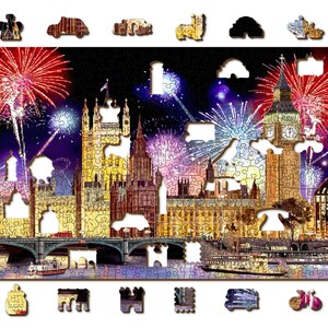 May include: A jigsaw puzzle depicting a nighttime view of the Houses of Parliament in London, England, with fireworks exploding in the sky above. The Big Ben clock tower is visible in the center of the image. The puzzle is made of wood and has a brown frame.