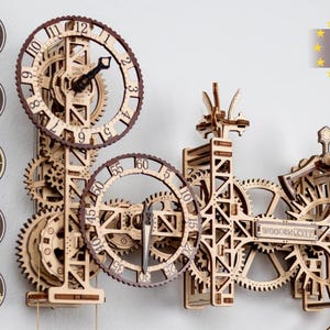 May include: A wooden 3D clock kit with intricate gears and a brown and white color scheme. The clock is made of 269 parts and takes 5 hours to assemble. It is self-assembly and requires no glue. The clock is made in the EU.