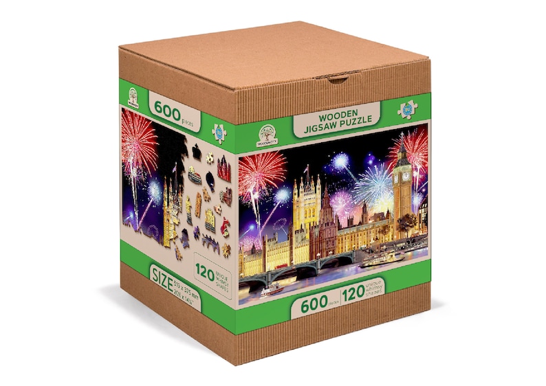 May include: A cardboard box with a green and white label featuring a 600-piece wooden jigsaw puzzle of the Houses of Parliament in London at night with fireworks. The puzzle is 120 cm x 80 cm.