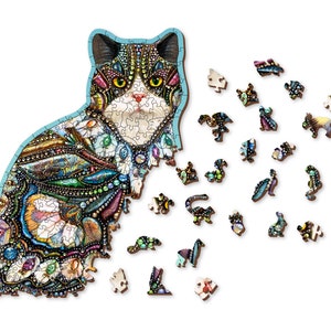 May include: A wooden jigsaw puzzle of a cat with a colorful mosaic design. The puzzle is partially assembled, with some pieces scattered around the cat.