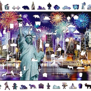 Könnte beinhalten: Ein Puzzle mit einer Nachtaufnahme der Skyline von New York City, über der Feuerwerkskörper explodieren. Die Freiheitsstatue steht im Vordergrund, und das Wasser ist dunkelblau mit Reflexionen der Lichter der Stadt.