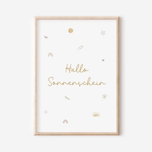 Könnte beinhalten: Ein gerahmter Druck mit einem hellen Holzrahmen. Der weiße Hintergrund zeigt kleine Illustrationen von Sonne, Regenbogen, Blumen und Bienen. Die Worte "Hallo Sonnenschein" sind in goldener Schrift geschrieben.