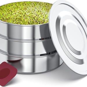 May include: A shiny, three-tiered stainless steel sprouting kit with a lid and a small, maroon-colored seed packet. The top tier is filled with vibrant green sprouts. The kit is designed for home gardening and growing fresh produce.