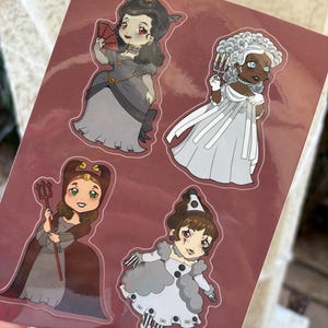 May include: A sheet of stickers featuring four cartoon characters in historical costumes. The characters are dressed in shades of gray, brown, and white. One character holds a fan, another a trident, and a third wears a clown-like outfit.