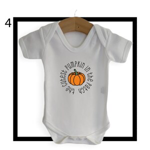 May include: White baby onesie with a pumpkin graphic and the text "The cutest pumpkin in the patch".
