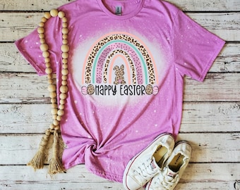 May include: Pink t-shirt with a bleached design of a rainbow with a bunny inside and the text "Happy Easter".