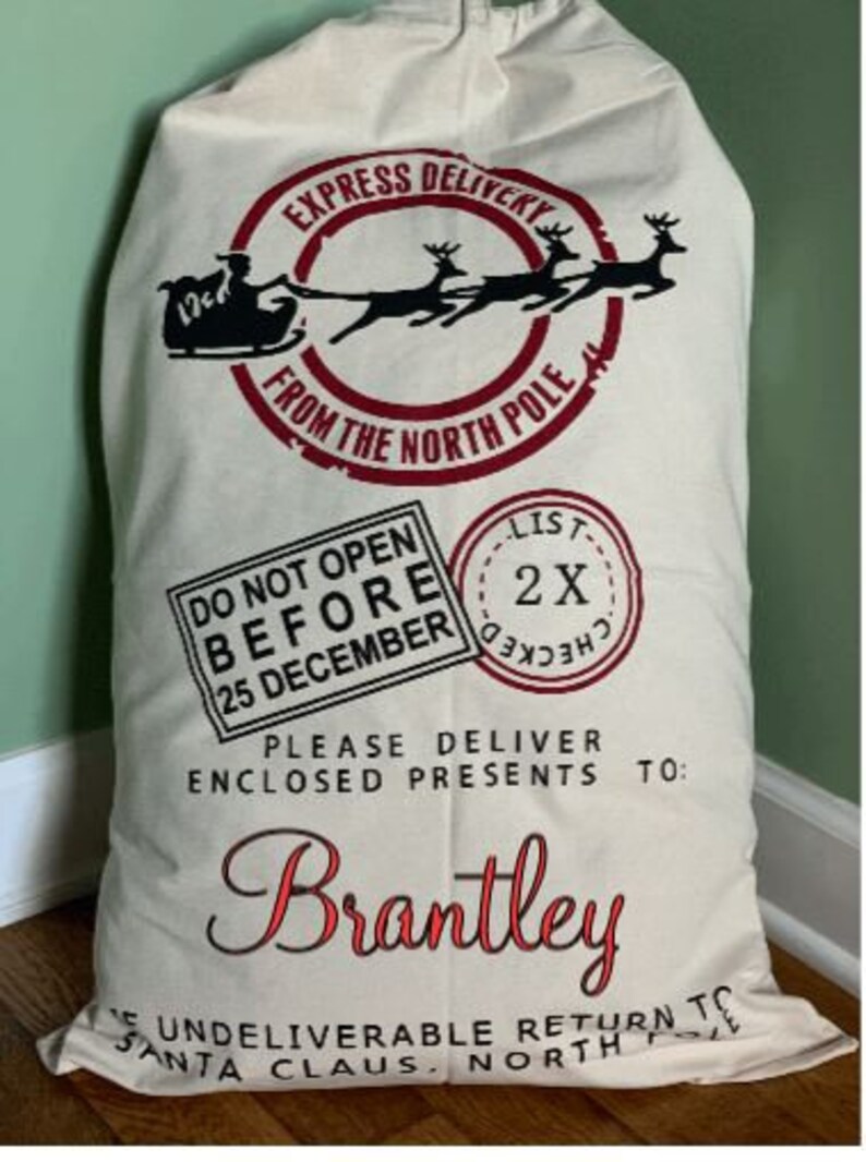 May include: A white canvas Santa sack with black and red text that reads "Express Delivery from the North Pole".  It also has a black and red graphic of Santa's sleigh with reindeer.  The text "Do Not Open Before 25 December" is printed in black and red.  The text "Please Deliver Enclosed Presents To: Brantley" is printed in black and red.  The text "Undelieverable Return To Santa Claus, North Pole" is printed in black and red.