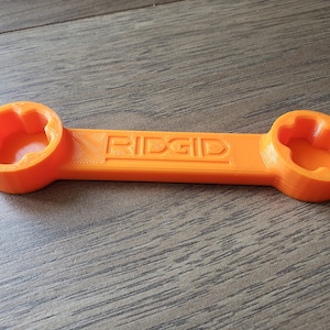 May include: An orange wrench with two 6-point sockets on either end. The wrench is labeled "RIDGID" in the center.
