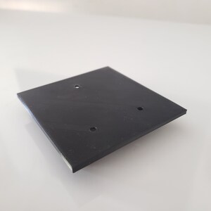 May include: A black square-shaped plastic plate with three holes.