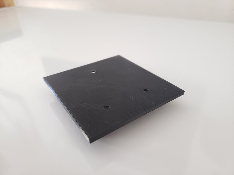 May include: A black square-shaped plastic plate with three holes.