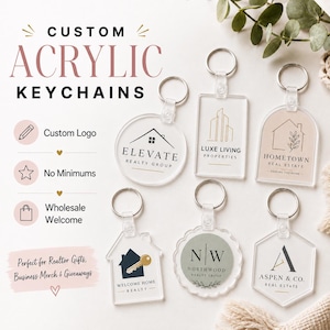 May include: Six clear acrylic keychains in various shapes including circle, rectangle, arch, house, scalloped circle, and hexagon. Each keychain features a unique black or gold printed real estate logo and a silver metal split ring attachment.