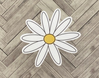 May include: A white daisy with a yellow center on a woodgrain background.