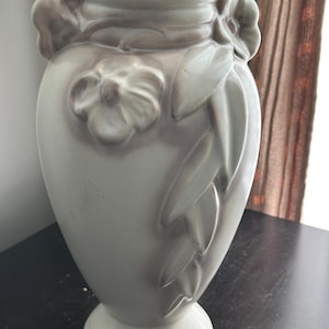 May include: A set of three ceramic mugs with a speckled, matte finish in cream, light grey, and dark grey. Each mug has a simple, minimalist design and a rounded handle.