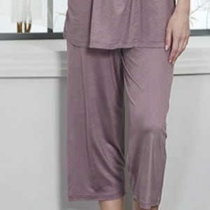 May include: A mauve-coloured pyjama set with a short-sleeved top and cropped trousers. The top has a gathered neckline and the trousers have a relaxed fit.