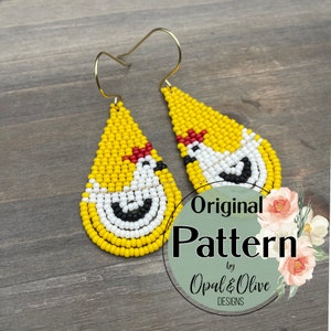 Peut inclure: Une paire de boucles d'oreilles en forme de goutte d'eau, composées de perles jaunes, blanches, rouges et noires, avec un motif de poulet. Les boucles d'oreilles sont étiquetées "Original Pattern by Opal & Olive Designs".