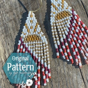 May include: A pair of handmade beaded earrings with a geometric pattern in white, gold, and red beads. The earrings are long and dangle, with a fringe of beads at the bottom. The earrings are labelled "Original Pattern by tyd handmade".