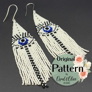 May include: White beaded earrings with a blue eye design and black accents. The earrings have a fringe design and silver hooks. The text "Original Pattern by Opal & Olive Designs" is in the lower right corner.