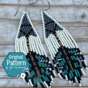 May include: A pair of long, beaded earrings with a geometric pattern in shades of gray, white, black, teal, and gold. The earrings are handmade and feature a fringe design.