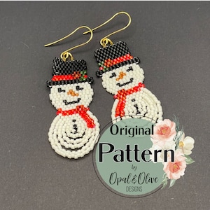 May include: A pair of beaded snowman earrings with black hats, red scarves, and white bodies. The earrings are made with small beads and have gold hooks. The earrings are labeled "Original Pattern by Opal & Olive Designs."