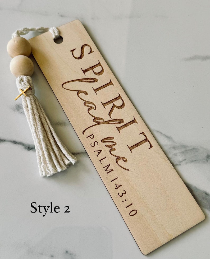 May include: Wooden bookmark with a white tassel and wooden beads. The bookmark has the text "SPIRIT lead me PSALM 143:10" engraved on it. Style 2.