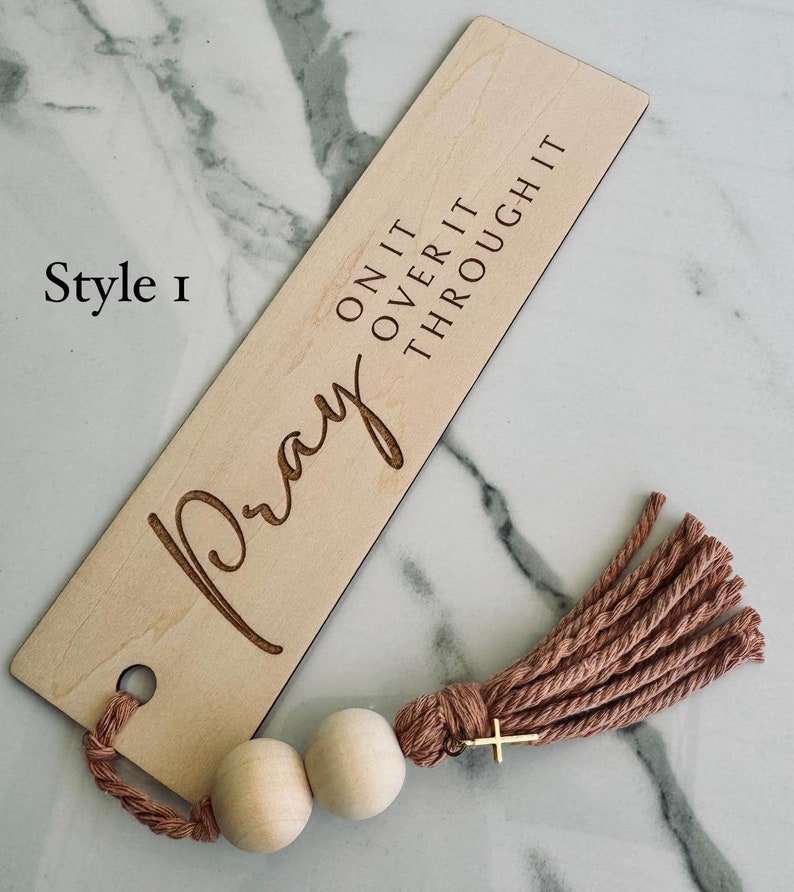 May include: Wooden bookmark with the words "Pray On It Over It Through It" and a tassel with wooden beads.