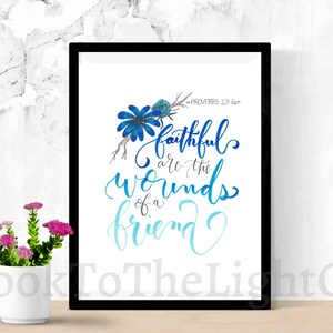 May include: A framed print with a blue floral design and the text "PROVERBS 27:6a faithful are the wounds of a friend".