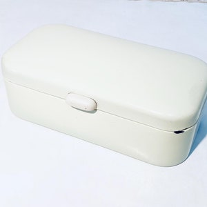 Può includere: Un porta pane in smalto bianco con coperchio a cerniera e chiusura in plastica bianca.